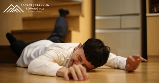 man lying on the ground after tripping down the stairs